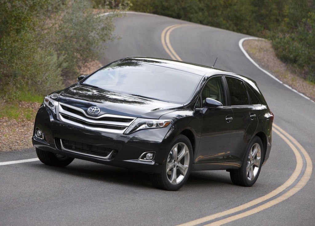 a black 2013 Toyota Venza poses in the middle of the road