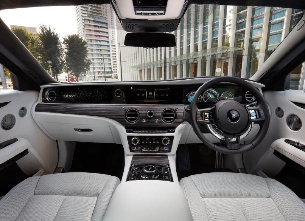 The white-leather-upholstered and wood-trimmed front interior of a UK-market 2021 Rolls-Royce Ghost