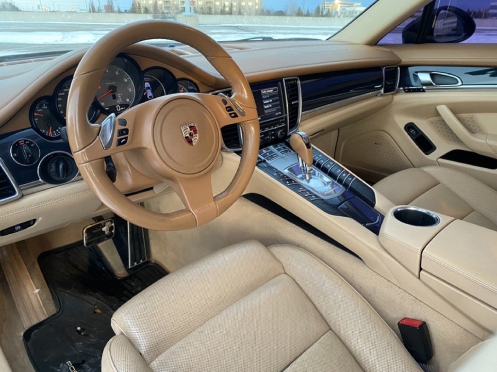 The tan-leather-covered front seats and dashboard of a used 2010 Porsche Panamera 4S