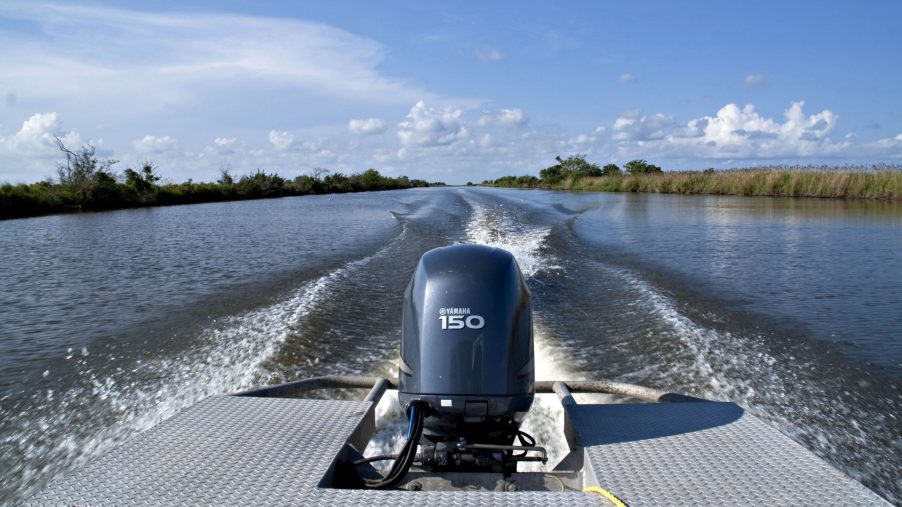 A Yamaha engine propels a boat near marshlands on the Harry Bourg Corp. preserve in Louisiana, U.S.
