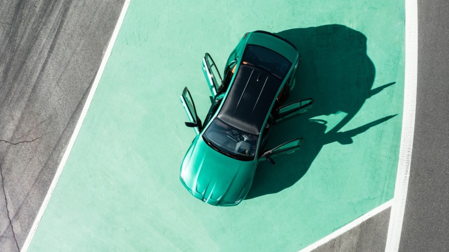 A top view of an emerald green BMW M3 on a green painted pavement