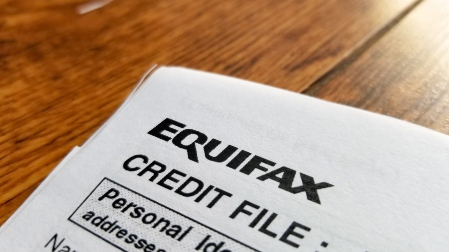 Close-up of the upper corner of a consumer credit report from the credit bureau Equifax, with text reading "Credit File" and "Personal Identification" on a light wooden surface on September 11, 2017