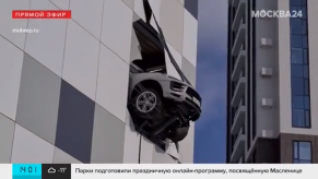Crashed Porsche Macan hangs off the side of a building teetering on the edge