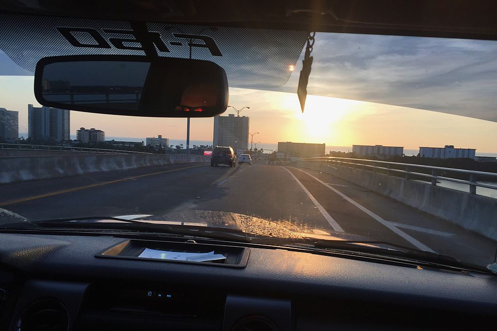 Overlooking the dashboard of a Ford F-150 traveling over the Dunlawton Bridge in Daytona Beach Florida as the sun rises