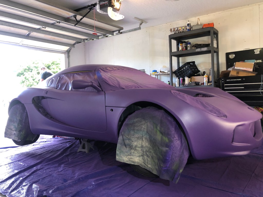 The purple base coat of Plasti Dip on my Lotus Elise as it sits on jack stands in the garage 