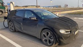 shrouded Kia "CV" that has yet to be released is siad to rival the Porsche Taycan
