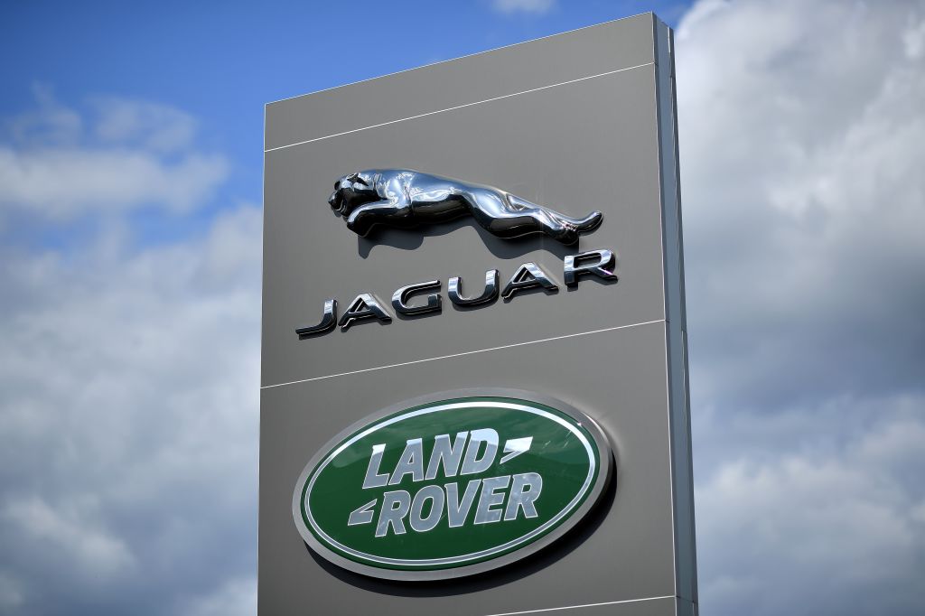 A tall Jaguar/Land Rover sign against a blue sky with white clouds