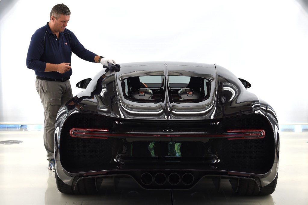 An employee cleans a car at the luxury automobiles manufacturer Bugatti's headquarters.