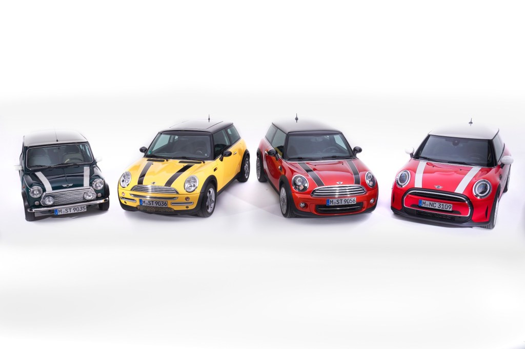 Four generations of Mini Cooper ranging from the newest model back, on a completely white background