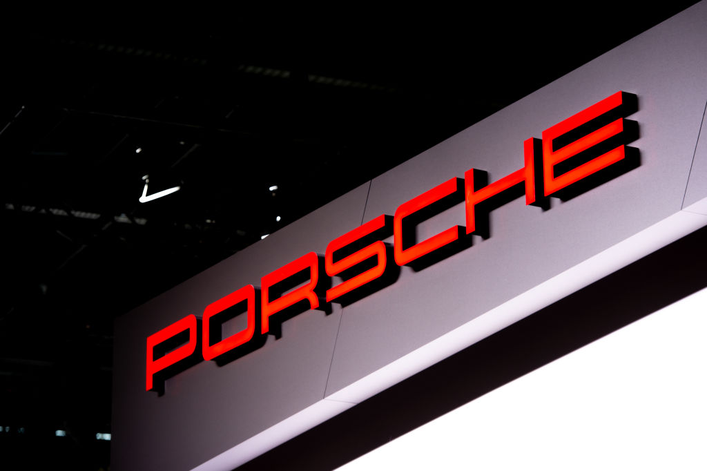 A red Porsche logo over a grey background