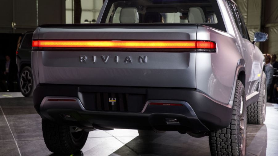 A silver Rivian R1T electric pickup truck, viewed from the rear