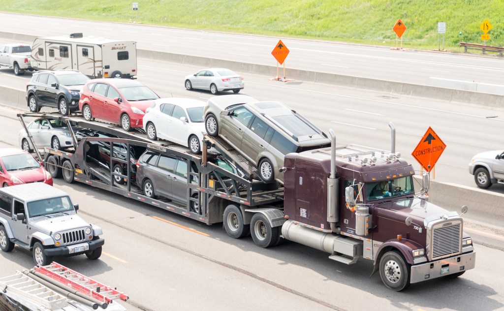 A trailer truck transporting cars being shipped.