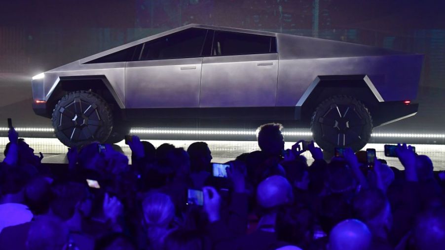 Stainless steel Tesla Cybertruck on display for a large crowd