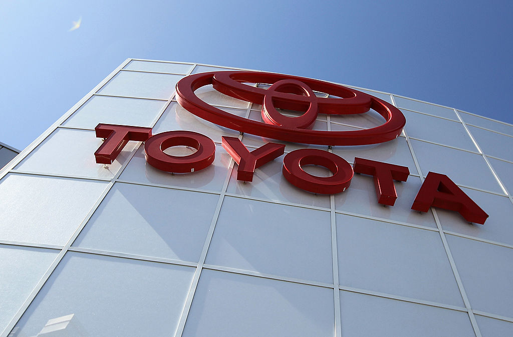 A red logo of the Lexus parent brand, Toyota, on the side of a white building