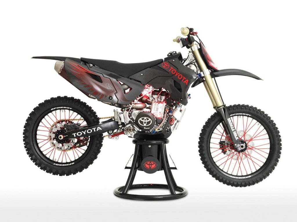 Toyota JGRMX motorcycle concept on a stand against a white back drop 