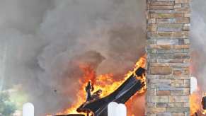 An image of a McLaren 765 LT on fire at a gas station.