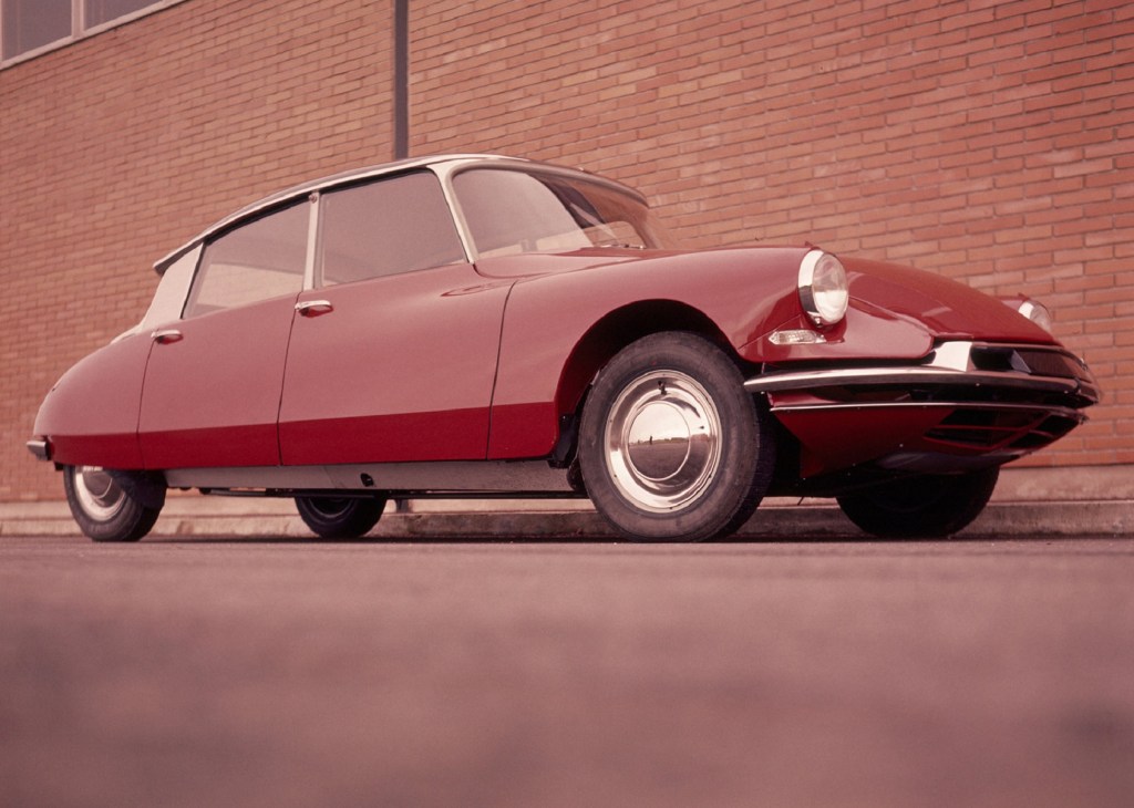A red 1960 Citroen DS 19 by a brick building