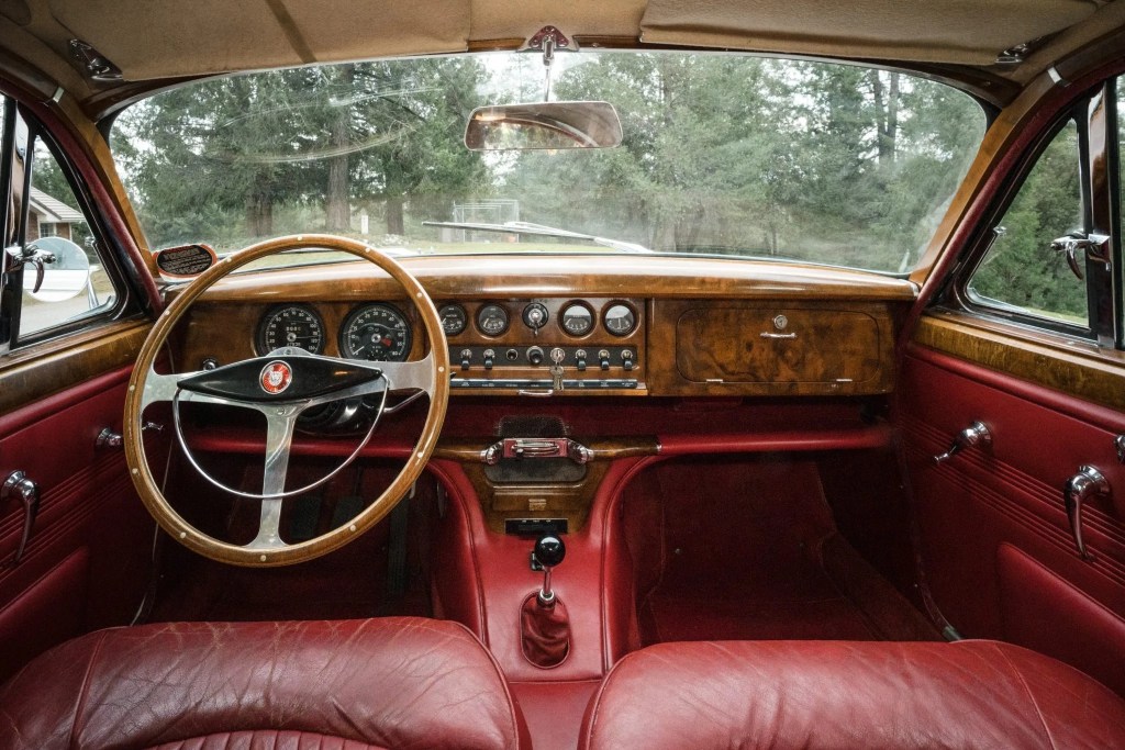 The red-leather-upholstered and wood-trimmed interior of a 1965 Jaguar S-Type 3.8