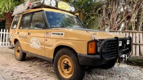 A yellow 1992 Land Rover Discovery Camel Trophy competitor on a sandy beach