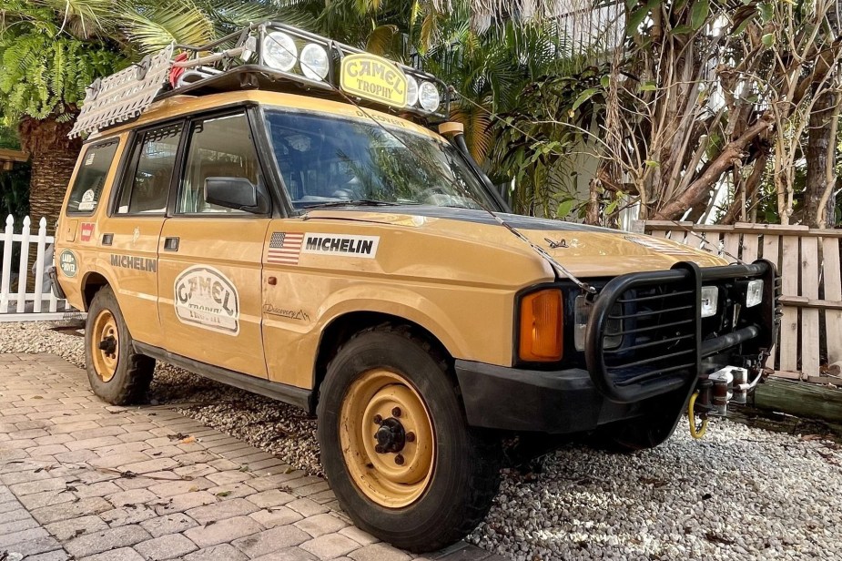 A yellow 1992 Land Rover Discovery Camel Trophy competitor on a sandy beach
