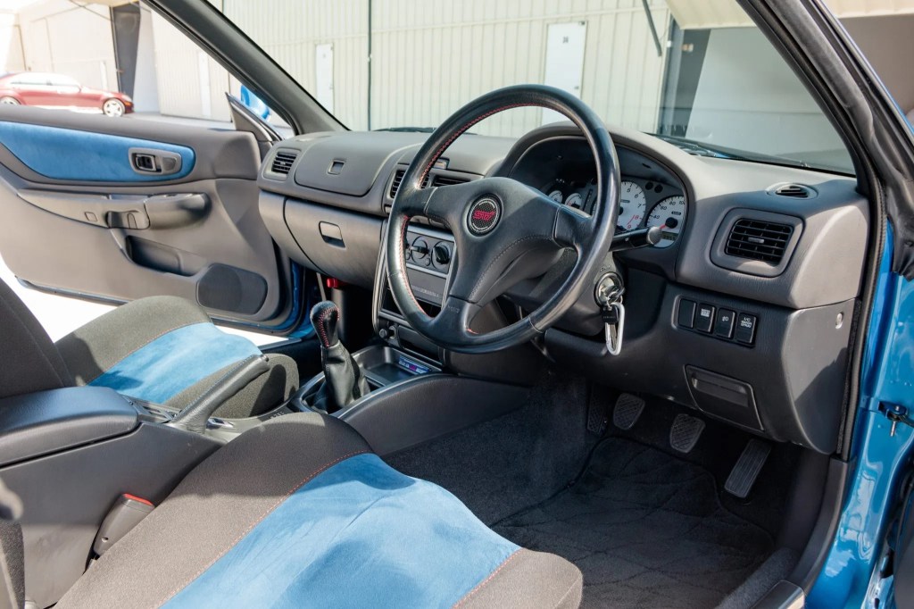 The blue-and-black Recaro front seats and dashboard of a 1998 Subaru Impreza 22B STi