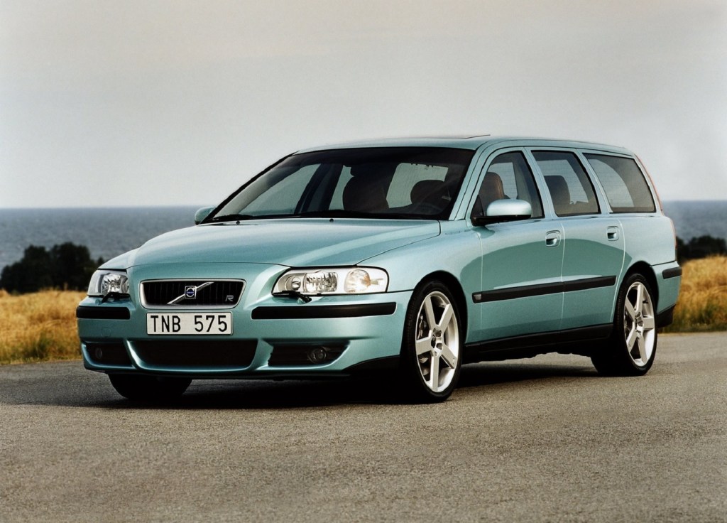 A teal 2003 Volvo V70R on a road by a body of water