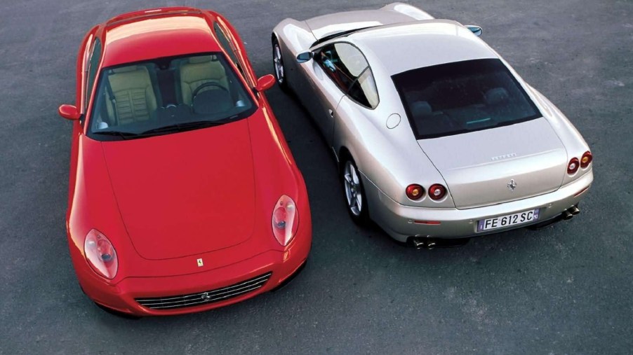 A front-facing red 2004 Ferrari 612 Scaglietti parked next to a rear-facing silver one