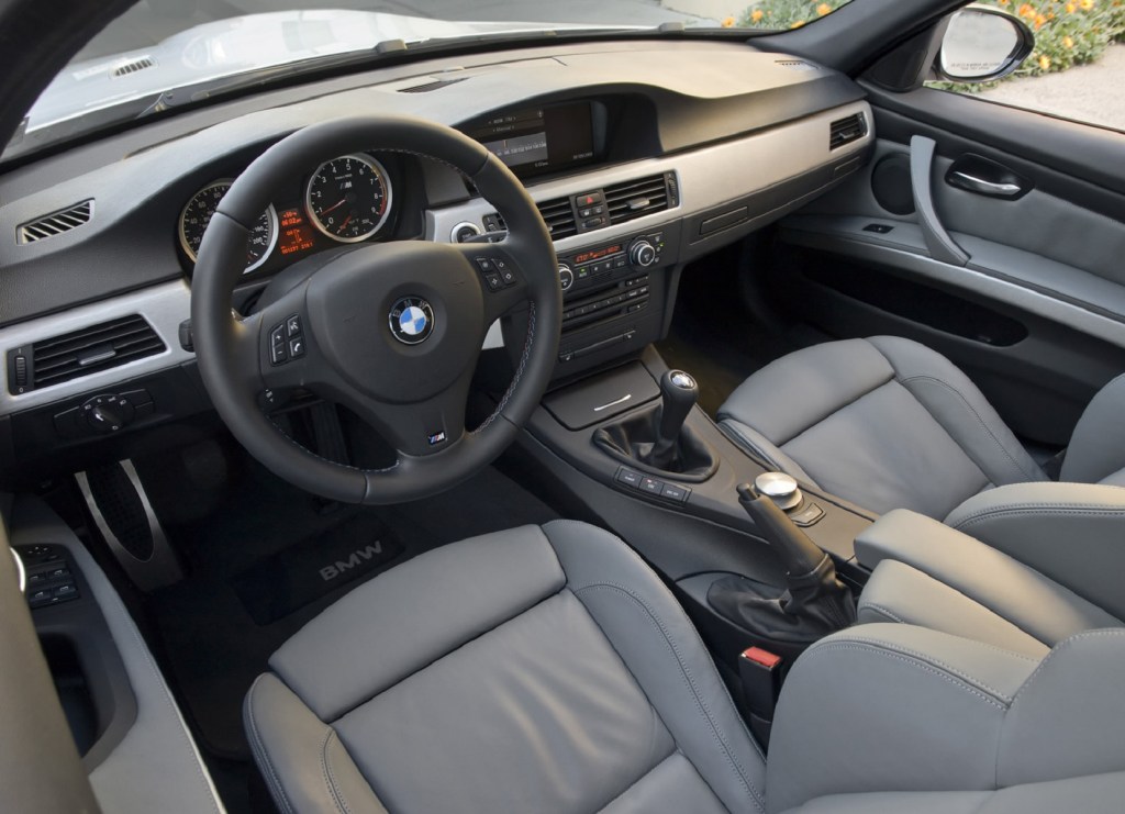 The gray-leather-upholstered front seats and silver dashboard of a 2008 E90 BMW M3 Sedan