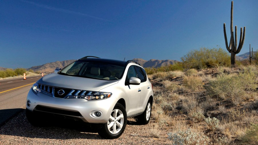 A pearl-white 2009 Nissan Murano midsize SUV parked on the side of the road near a cactus in Sedona, Arizona, during a media preview on December 3, 2007