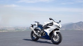 A white-and-blue 2016 Triumph Daytona 675 on a mountainside parking lot