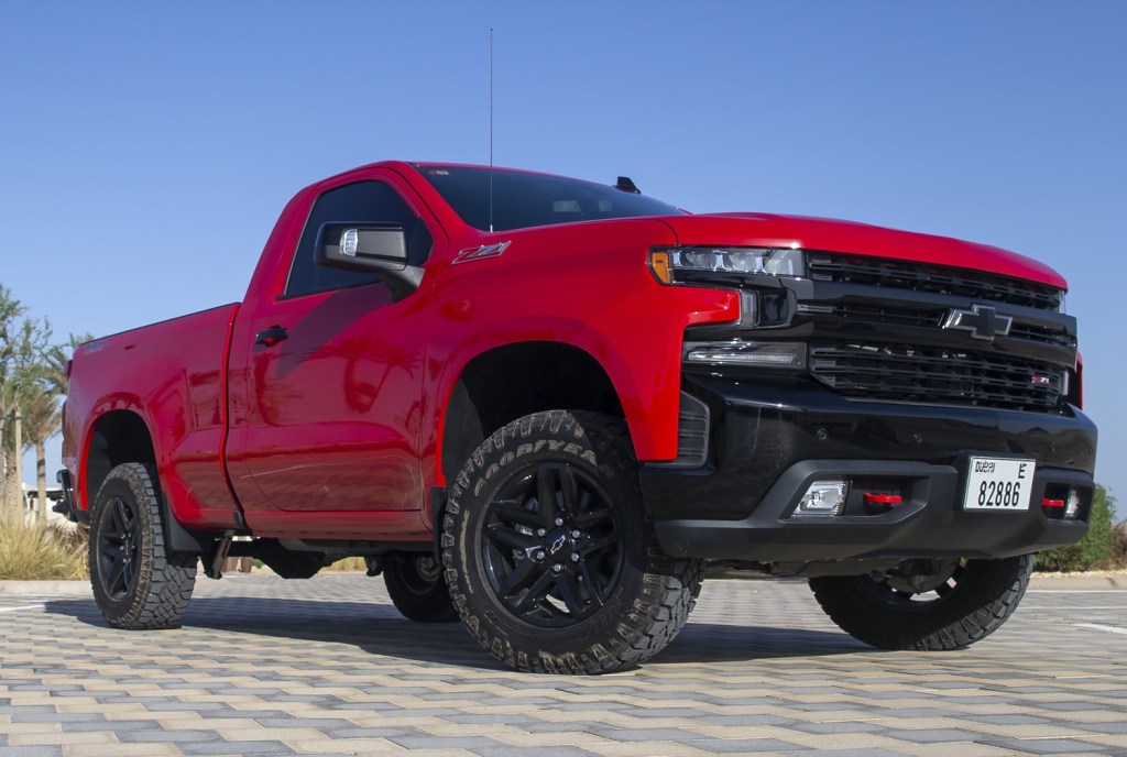 front 3/4 view of red single cab, short bed Silverado.