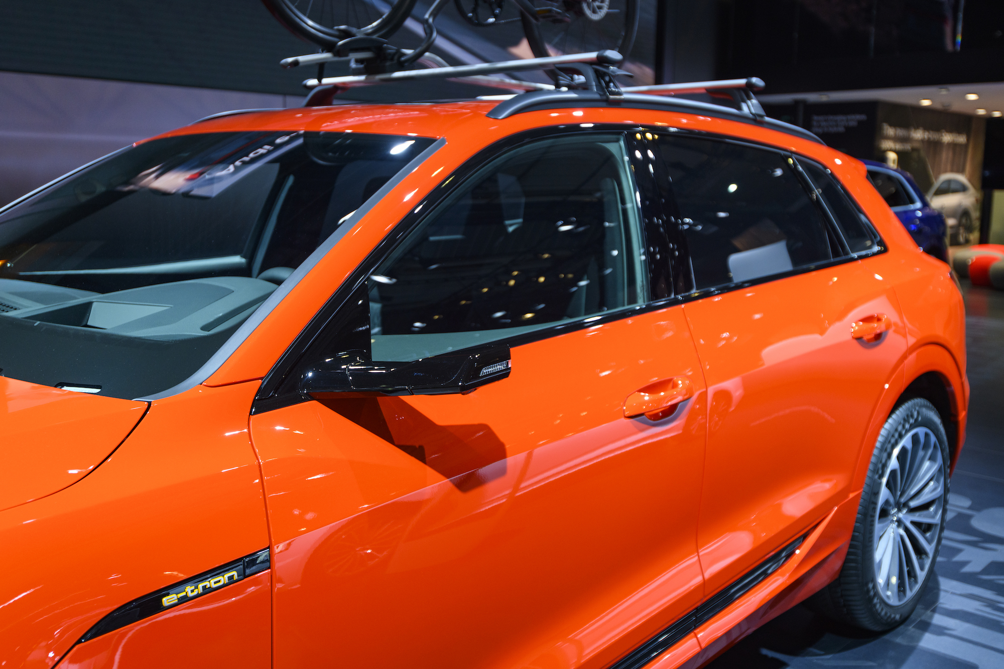 An orange 2020 Audi e-tron 55 Quattro all-electric luxury crossover SUV on display at Brussels Expo on January 9, 2020, in Brussels, Belgium