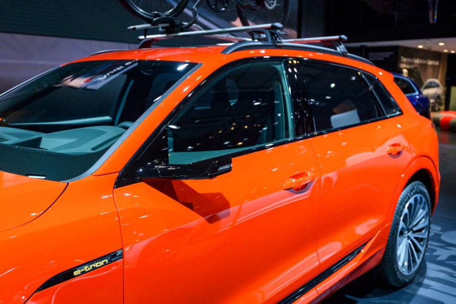 An orange 2020 Audi e-tron 55 Quattro all-electric luxury crossover SUV on display at Brussels Expo on January 9, 2020, in Brussels, Belgium