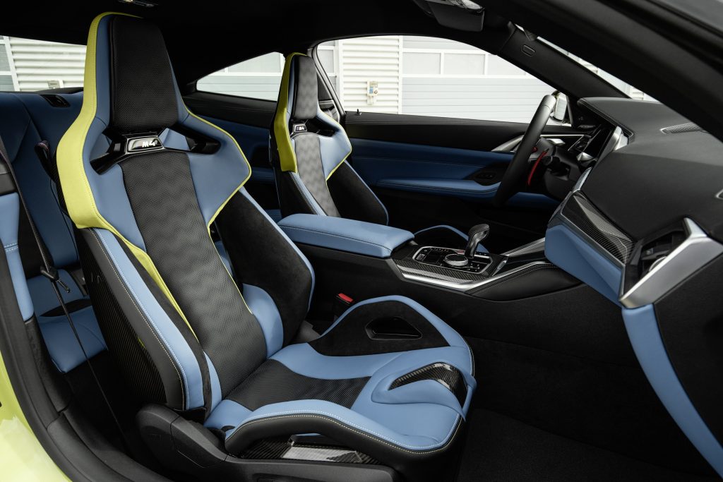 The blue-and-green-leather-upholstered seats and black-and-blue dashboard of a 2021 BMW M4 Competition