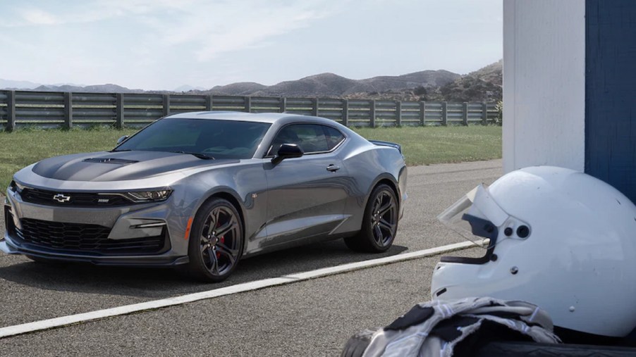 A gray 2021 Chevrolet Camaro SS 1LE on a track with a white helmet in the foreground