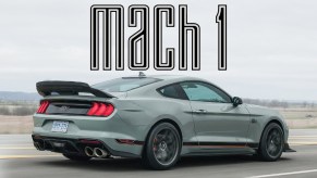 The side 3/4 view of a gray 2021 Ford Mustang Mach 1 driving down a road