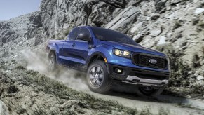 A blue 2021 Ford Ranger XLT SuperCab FX4 drives down a mountainside gravel road