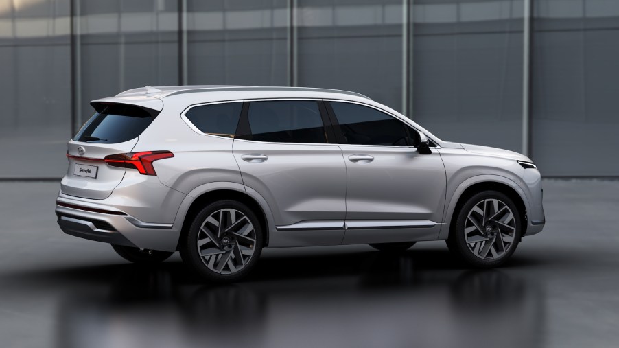 A pearl-white 2021 Hyundai Santa Fe Calligraphy Model midsize crossover SUV parked in a large gray garage