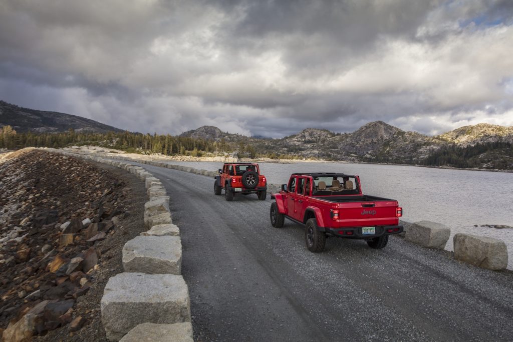 The 2021 Jeep Gladiator and Jeep Wrangler being driven on a cloudy day