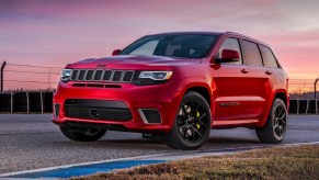 A red 2021 Jeep Grand Cherokee Trackhawk on a racetrack at sunset