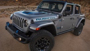 A close-angle front 3/4 view of a gray 2021 Jeep Wrangler Rubicon 4xe in the desert mountains
