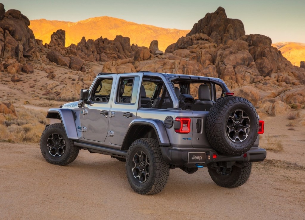 The rear 3/4 view of a gray 2021 Jeep Wrangler Rubicon 4xe in the desert mountains. Currently the second fastest-selling car in America. 