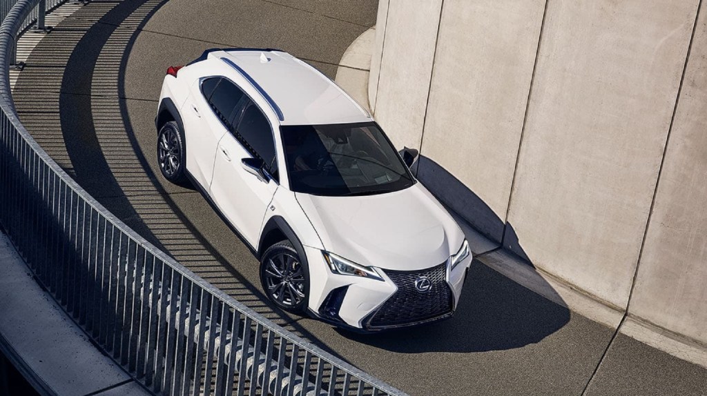 An overhead of a white 2021 Lexus UX 250h driving down a curving road