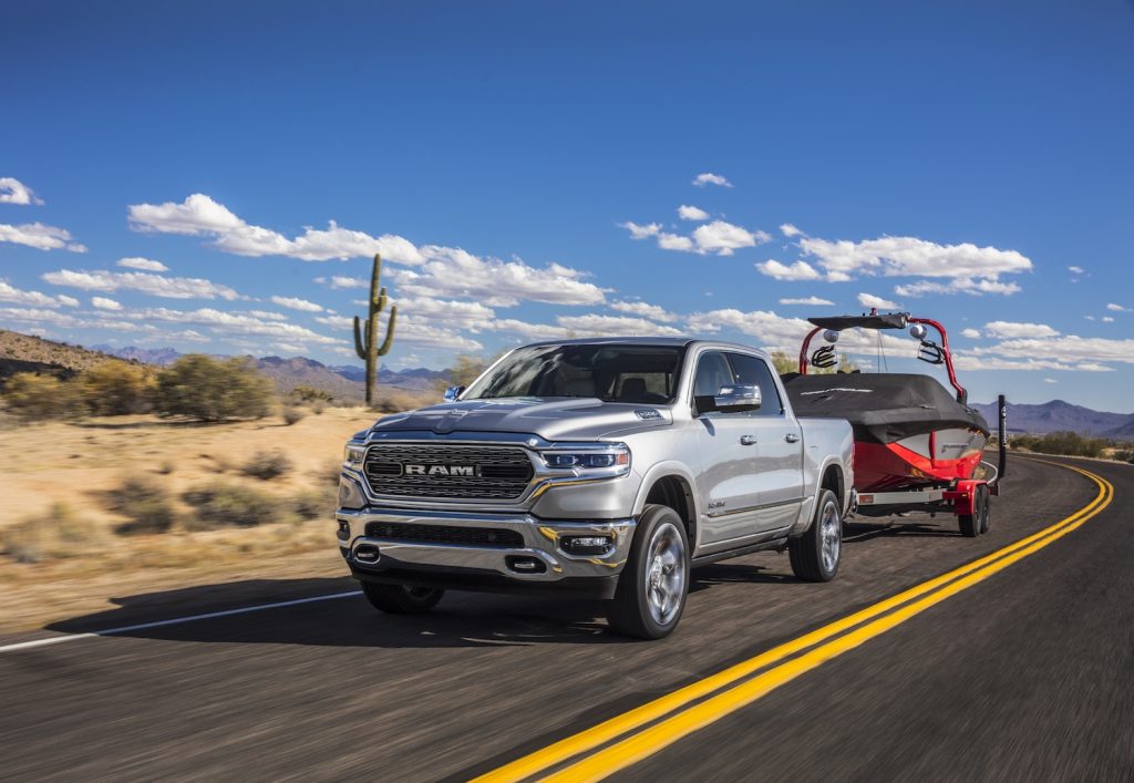 Pictured is one of the best trucks for towing, the 2021 Ram 1500 Limited, as it tows a boat.