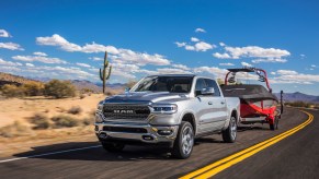 Pictured is one of the best trucks for towing, the 2021 Ram 1500 Limited, as it tows a boat.