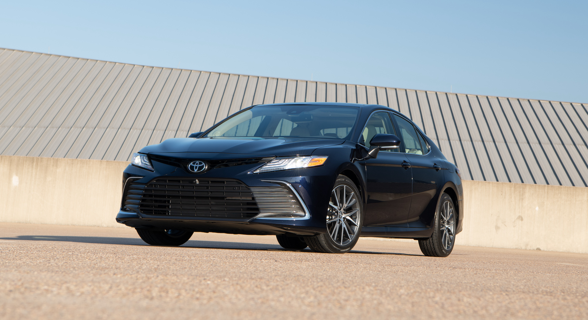 A dark-blue 2021 Toyota Camry XLE midsize sedan parked on a roof on a clear day