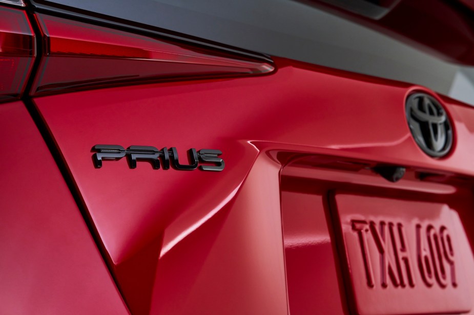 A closeup of the left rear area of a red 2021 Toyota Prius hybrid car
