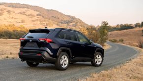 A 2021 Toyota RAV4 XLE Hybrid compact crossover SUV with Blueprint exterior paint parked on a rural road