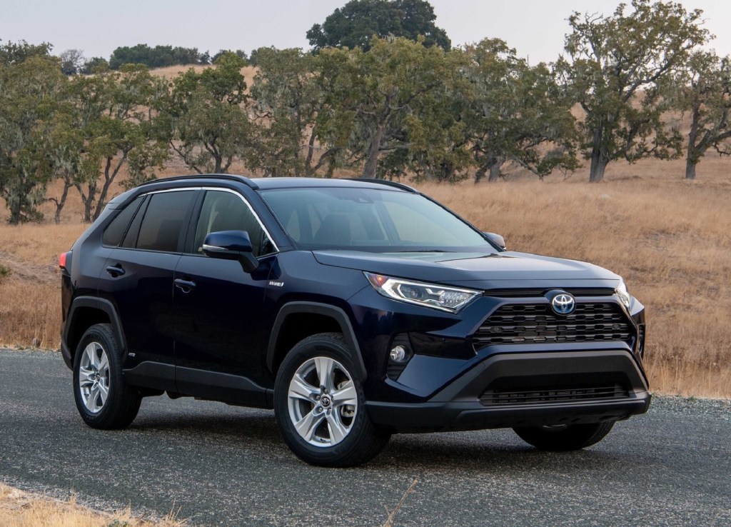 A dark-blue 2021 Toyota RAV4 XLE Hybrid on a plains road