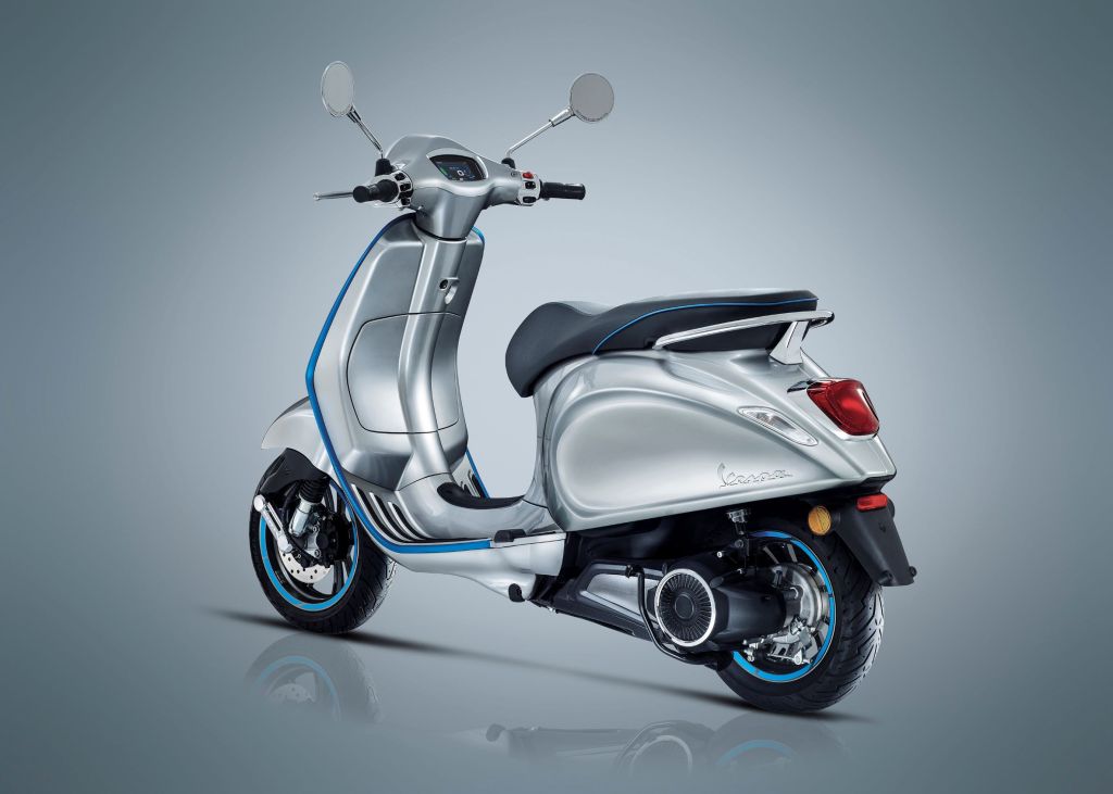 The rear 3/4 view of a silver-and-blue 2021 Vespa Elettrica